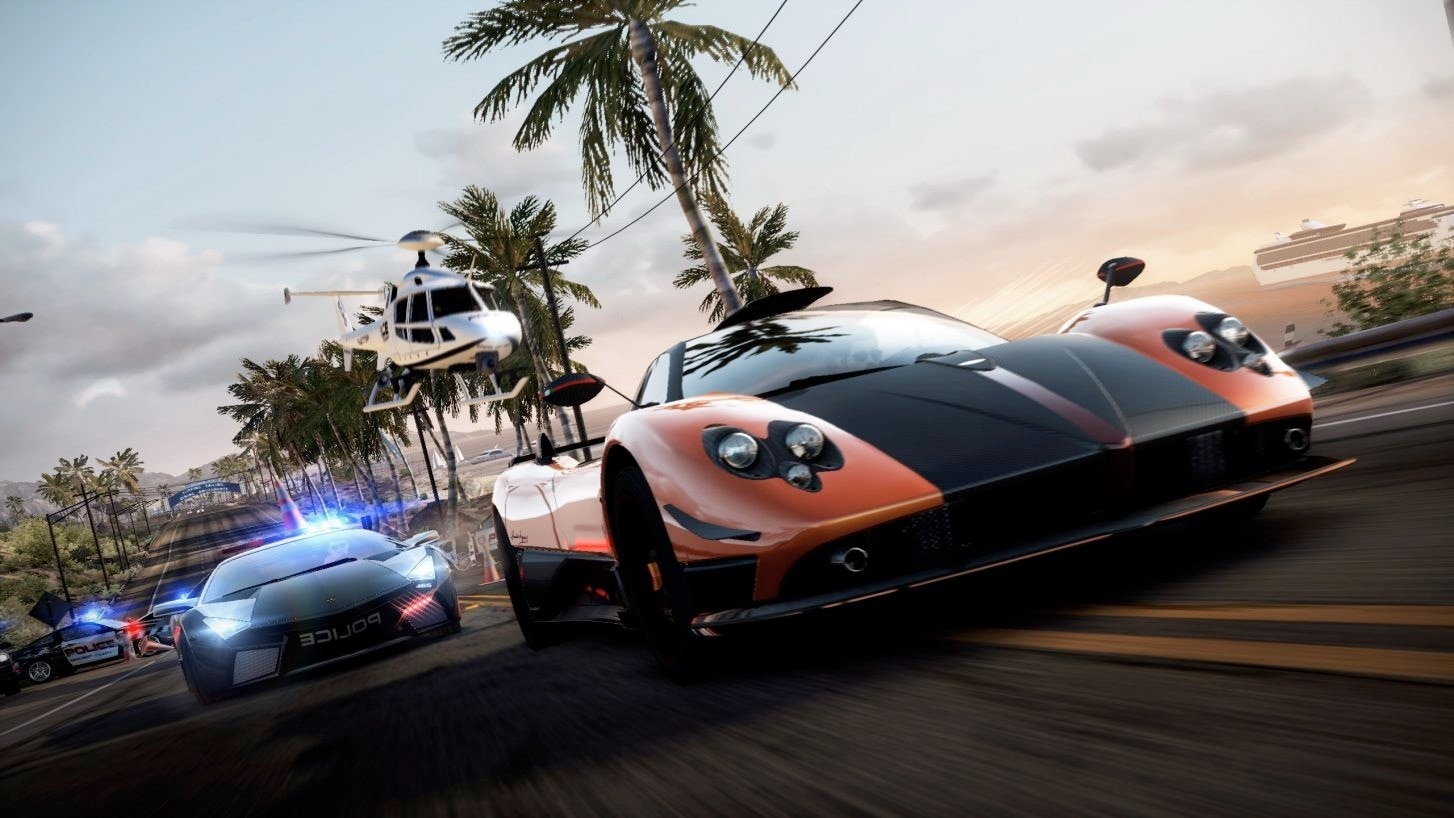 NFS Hot Pursuit Remastered screenshot showing sports car fleeing police helicopter on palm-lined road